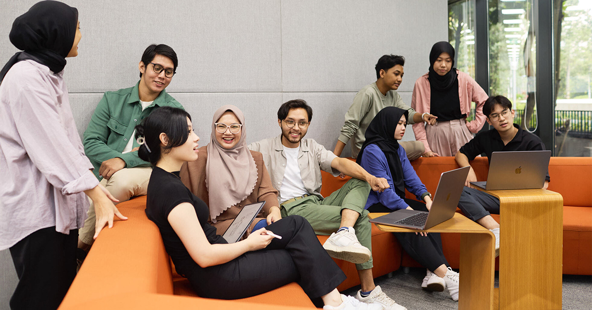 Developers collaborating in lounge area with orange couch
