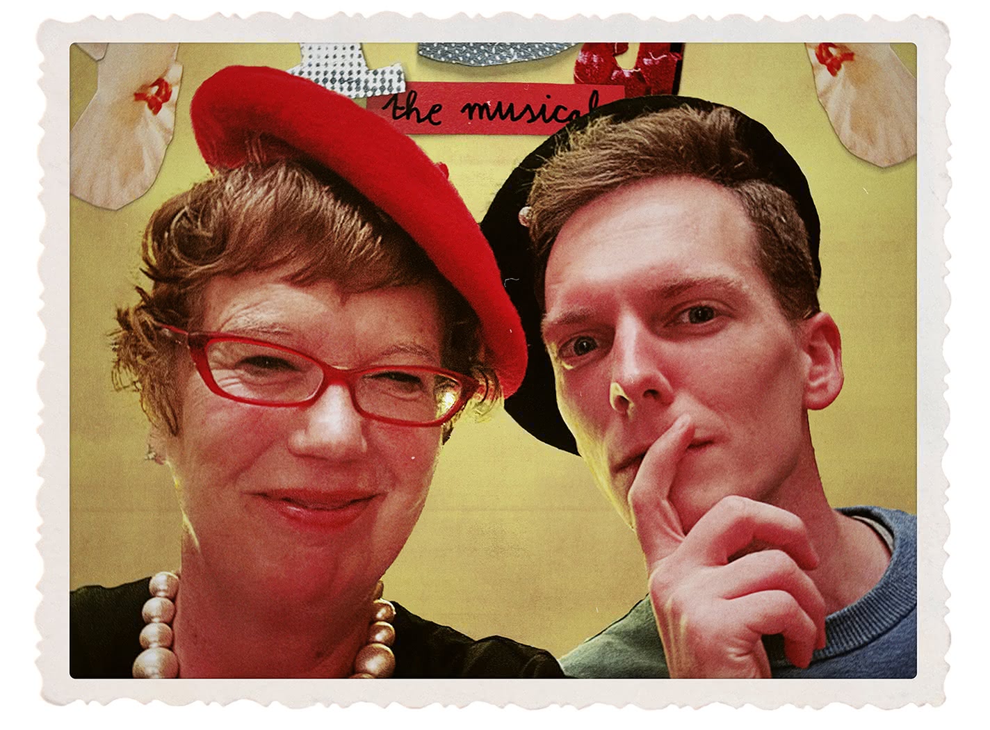A photo of two people, cut out and set against a tan parchment-style background. On the left, a woman is wearing red sunglasses, a red beret, and a large pearl necklace. On the right, a man is wearing a black hat and looking thoughtfully into the camera.